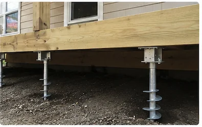 Installed helical screw piles supporting a wooden deck — galvanized steel foundation
